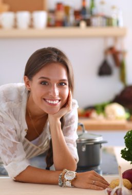 Mutfakta masanın yanında duran genç bir kadın.