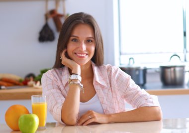 Mutfakta masada oturan genç bir kadın.