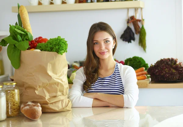 Young woman sitting in kitchen at home — Stock Photo, Image