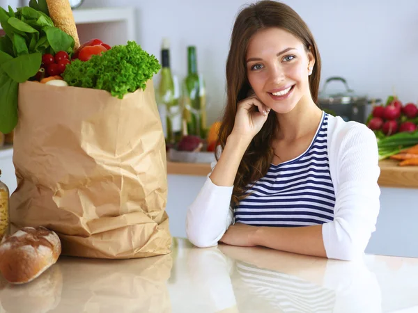 Young woman sitting in kitchen at home — Stock Photo, Image