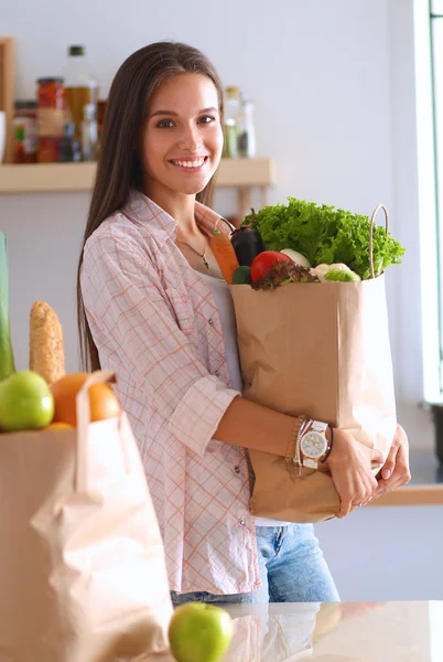 Jeune femme tenant sac d'épicerie avec des légumes — Photo