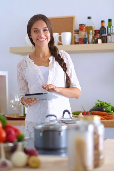 Jeune femme utilisant une tablette informatique pour cuisiner dans sa cuisine — Photo