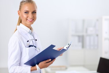 Hastanede üniformalı, gülümseyen bir kadın doktor.