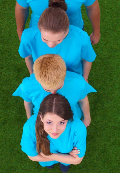 Group of young  people standing on green grass — Stock Photo, Image