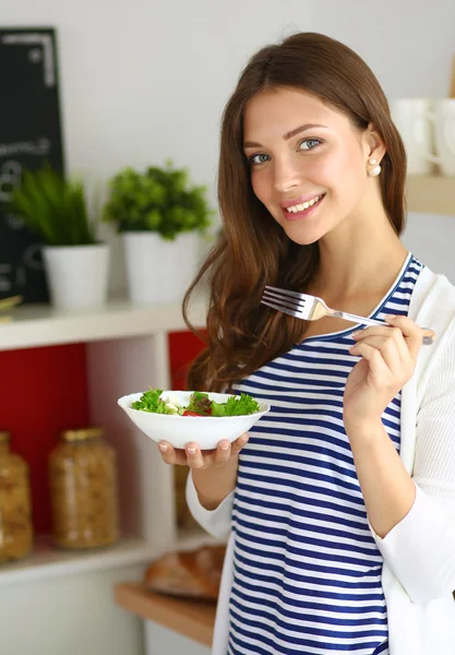 Jonge vrouw salade eten en het bedrijf van een gemengde salade — Stockfoto