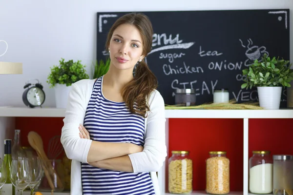 Giovane donna in piedi in cucina a casa — Foto Stock