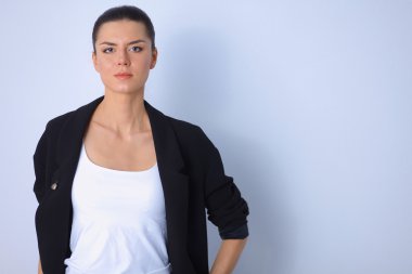 ayakta, gri arka plan üzerinde izole genç kadın