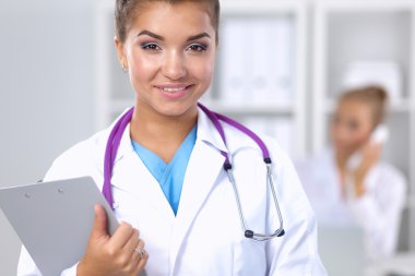 Hastanede üniformalı, gülümseyen bir kadın doktor.