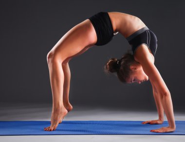 Mat Yoga egzersiz yaparak genç bir kadın