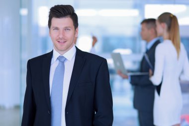 arka planda meslektaşları ile Office genç işadamı portresi