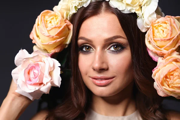 Retrato de uma mulher bonita com flores no cabelo. Moda — Fotografia de Stock