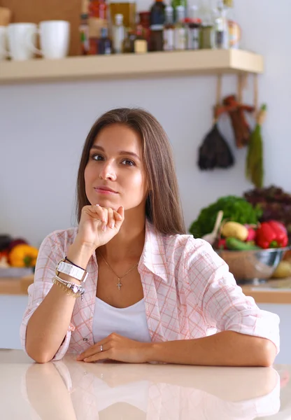 Portrait d'une jolie femme assise dans la cuisine — Photo