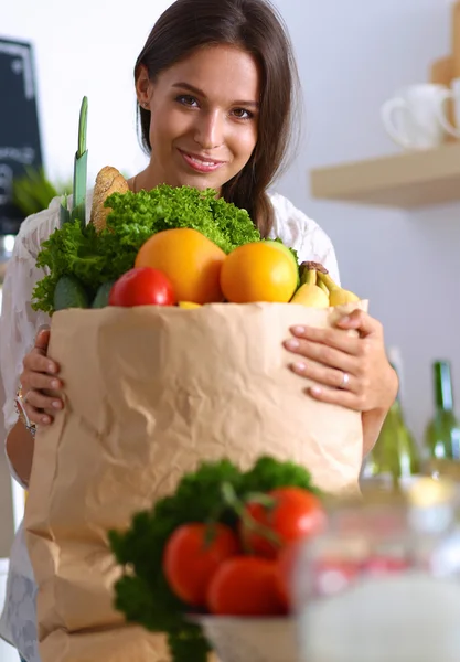 Ung kvinna med livsmedelsbutiker shoppingväska med grönsaker och frukt — Stockfoto