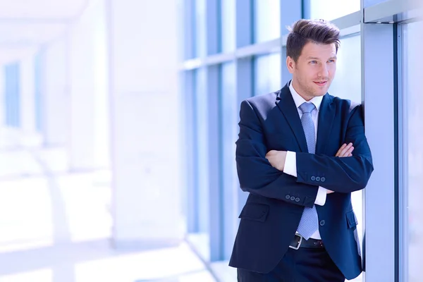 Retrato del hombre de negocios de pie cerca de la ventana en la oficina —  Fotos de Stock