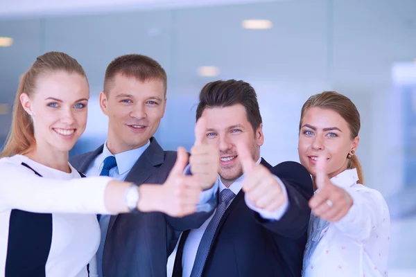 Feliz equipo de negocios mostrando pulgares hacia arriba en la oficina —  Fotos de Stock