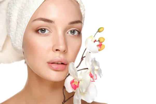 Mujer en toalla con flores de orquídea —  Fotos de Stock