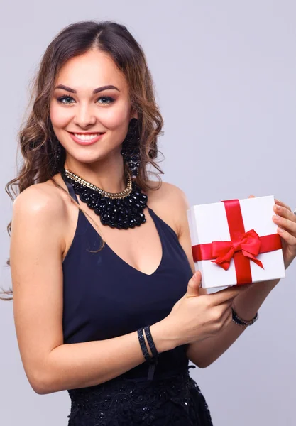 Young woman happy smile hold gift box in hands, isolated over grey background — Stock Photo, Image