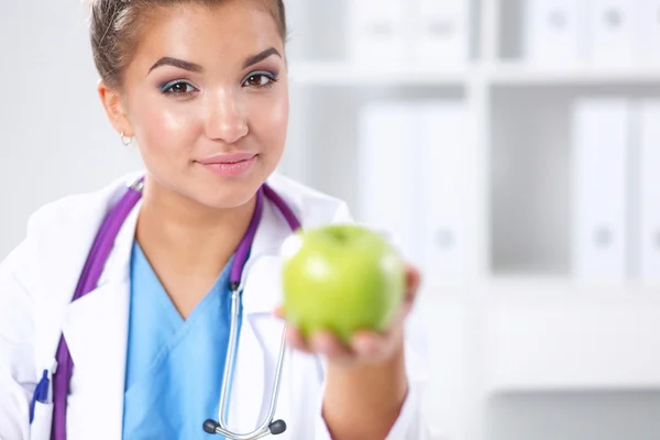 一位女医生手拿着一个绿色的苹果，站 — 图库照片