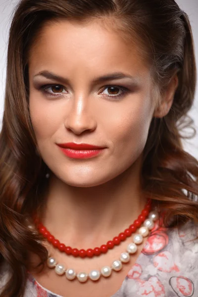 Portrait of young beautiful brunette woman in beads — Stock Photo, Image