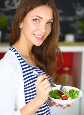 Salata yemek ve karışık salata tutan genç kadın 