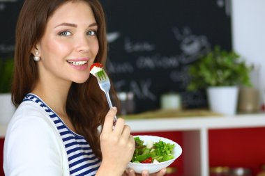 Salata yemek ve karışık salata tutan genç kadın 