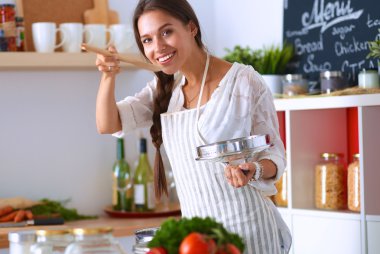 Mutfakta ahşap kaşıkla yemek pişiren kadın