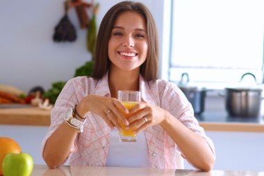 Mutfakta masada oturan genç bir kadın.