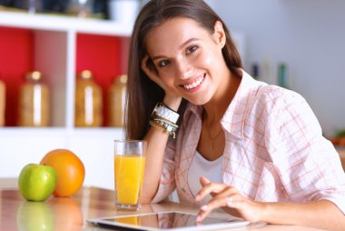 Mutfakta masada oturan genç bir kadın.