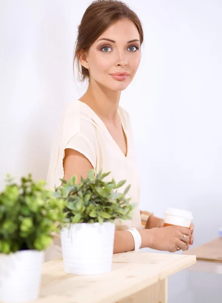 Hermosa mujer sosteniendo la olla con una planta, de pie — Foto de Stock