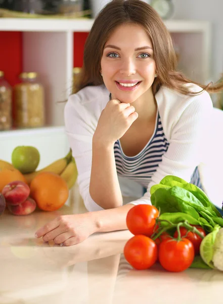 Junge Frau steht neben Schreibtisch in der Küche — Stockfoto