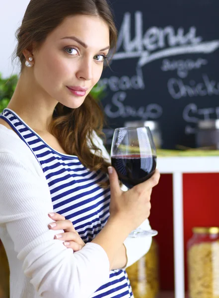 Söt kvinna dricker lite vin hemma i köket — Stockfoto