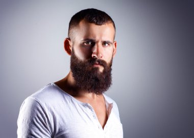 ayakta, gri arka plan üzerinde izole yakışıklı sakallı adam portresi