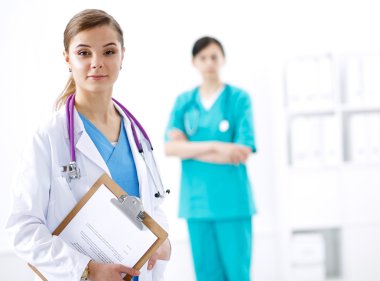 Kadın doktor hastanede dosyayla bekliyor.