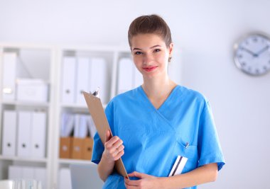 Hastanede üniformalı, gülümseyen bir kadın doktor.
