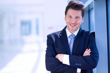 Ofisteki pencerenin yanında duran işadamının portresi