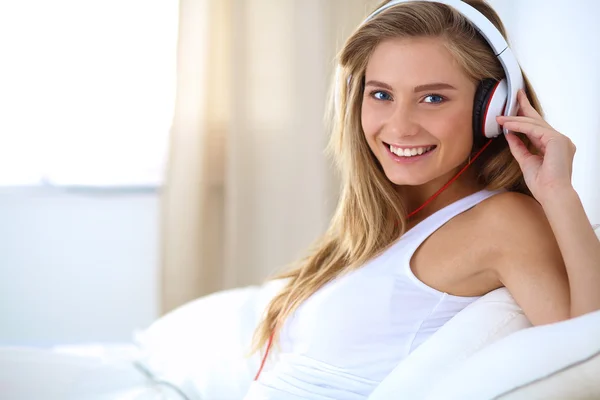 Retrato de una hermosa mujer en la mañana escuchando música sentada en la cama en casa — Foto de Stock