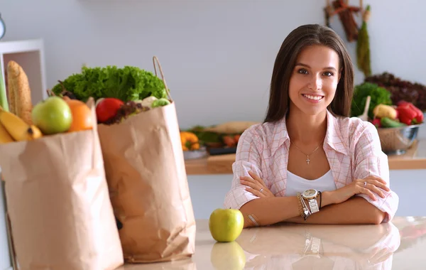 Jeune femme assise près du bureau dans la cuisine — Photo