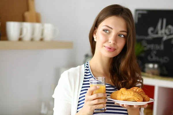 Mujer joven con vaso de jugo y pasteles —  Fotos de Stock