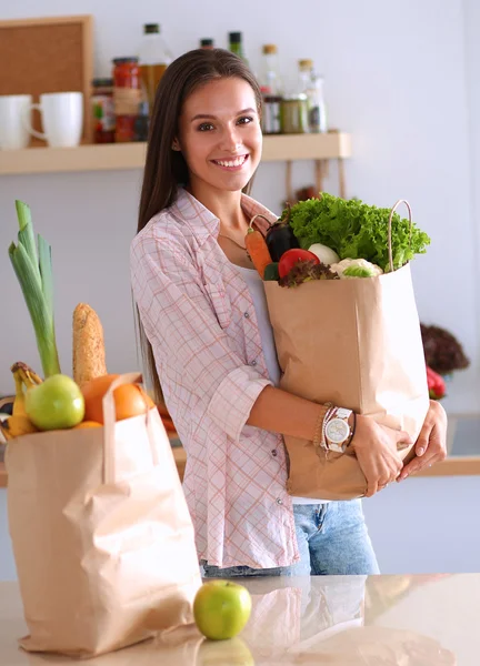 Young woman holding grocery shopping bag with vegetables — Stock Photo, Image