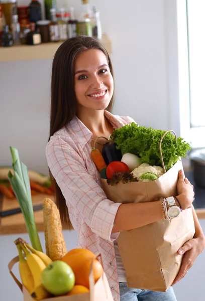 Junge Frau hält Einkaufstüte mit Gemüse — Stockfoto