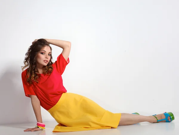 Young woman sitting on the floor, isolated in white background — Stock Photo, Image