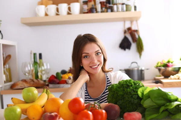 Jonge vrouw zit in de buurt van bureau in de keuken — Stockfoto