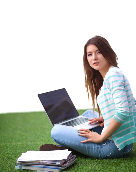 Young woman with laptop sitting on green grass — Stock Photo, Image