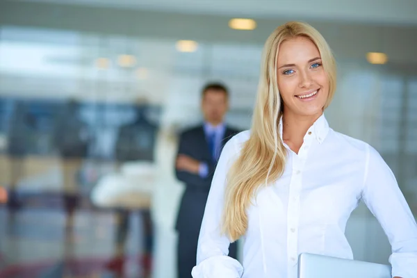 Portret van jonge zakenvrouw in functie met collega 's op de achtergrond — Stockfoto