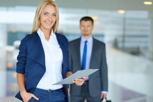 Portret van jonge zakenvrouw in functie met collega 's op de achtergrond — Stockfoto