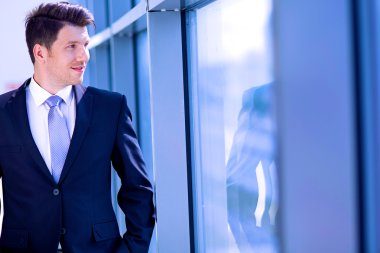 Ofisteki pencerenin yanında duran işadamının portresi