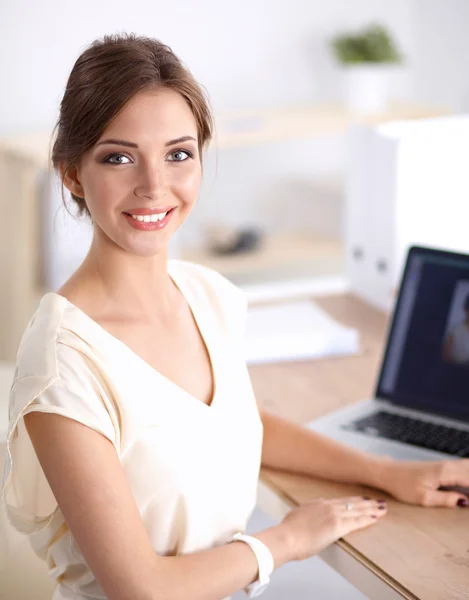 Retrato de uma mulher de negócios sentada na mesa com laptop — Fotografia de Stock