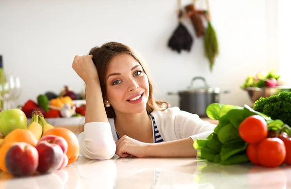 Mladá žena stojící u stolu v kuchyni — Stock fotografie