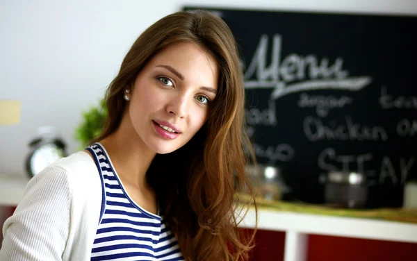 Giovane donna in piedi in cucina a casa — Foto Stock