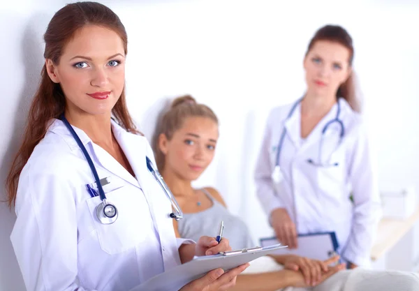 Médico sonriente con una carpeta en uniforme de pie en el hospital — Foto de Stock